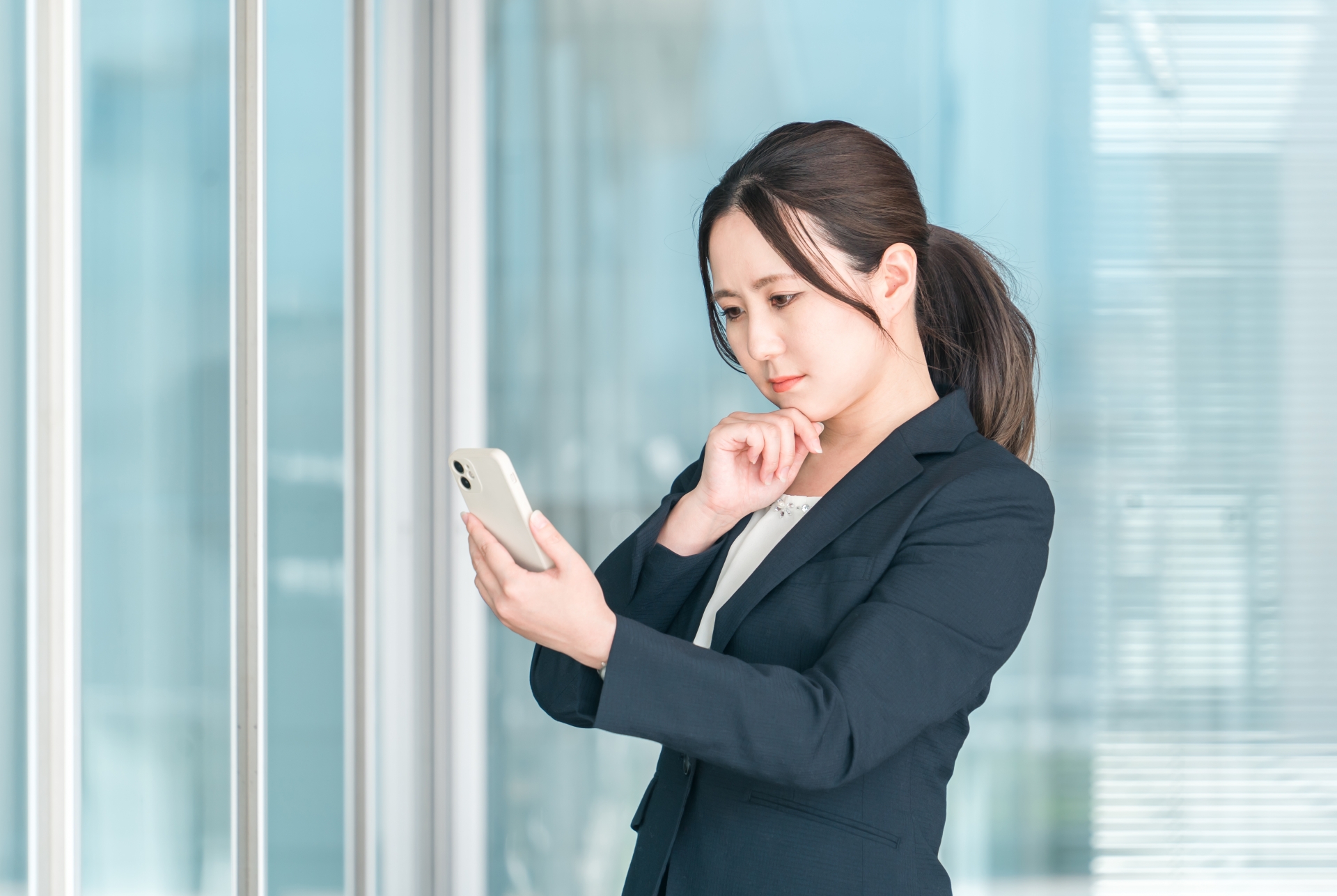 総合商社の選考について考えるスーツ姿の女性